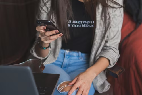 A person interacting with a phone and laptop, symbolizing digital engagement within the community.