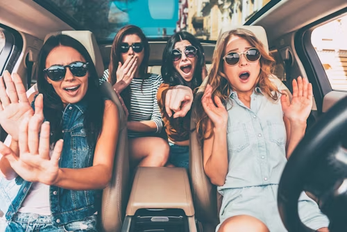 Four women in a car with surprised expressions, symbolizing unexpected thrills and reactions.