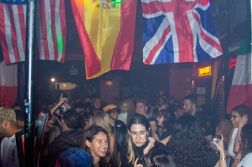 A crowded party with international flags, symbolizing a global community and collective frenzy.